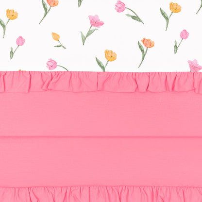 Close up of the Ruffle Toddler Blanket in Tulip 0.5 showing the pink packing, ruffled edges and floral print top layer