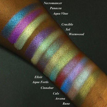 Top angled arm swatches on deep skin tone of Rune Duochrome Eyeshadow amongst the Witchcraft vs. Alchemy Collection