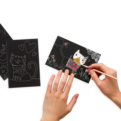 Lifestyle image of person using the Cutie Cats Scratch and Scribble Mini Scratch Art Kit