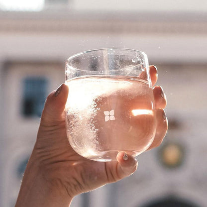 Hand holding a Signature Glass from a set of 2, made of odourless borosilicate glass, designed for an elegant, minimalist drinking experience.
