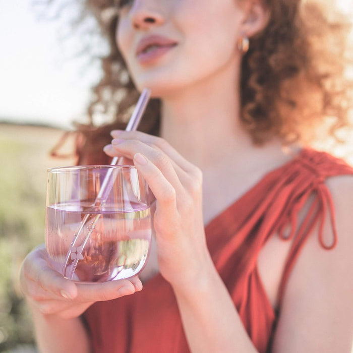 Woman drinking water using Signature Glasses, showcasing elegant, odourless borosilicate glass, perfect for refreshing hydration experiences.