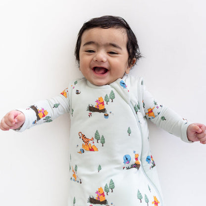 Close up of an infant wearing the Sleep Bag in Winnie the Pooh Hundred Acre Wood 1.0 with a matching romper on underneath