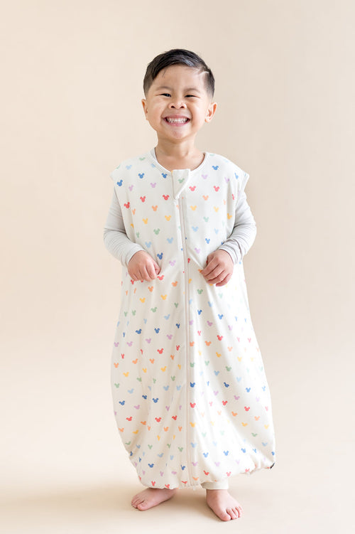 Young boy wearing sleep bag walker with colorful mickey head pattern