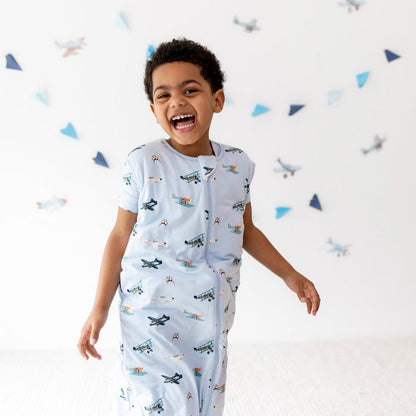 Smiling boy walking wearing the Sleep Bag Walker in Take Off 1.0