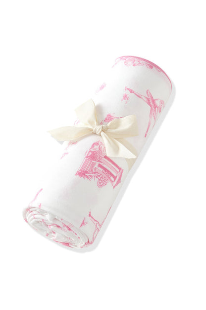 Swaddle Blanket in Toile Ballet shown rolled in its packaging tied with a linen bow