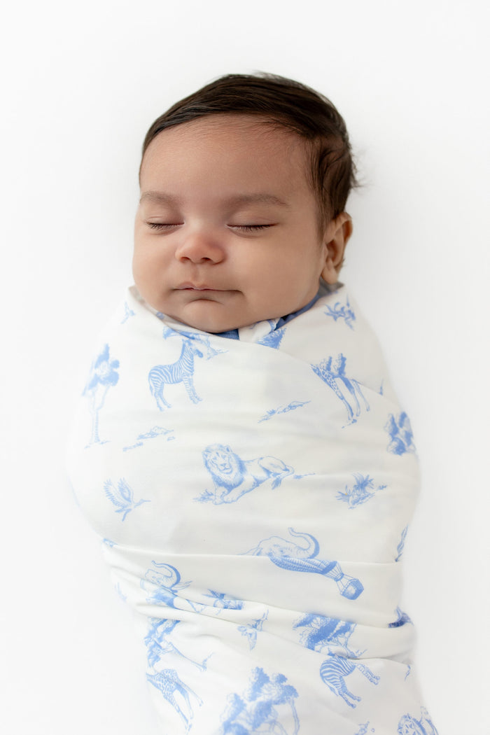 Close up of sleeping newborn swaddled in the Swaddle Blanket in Toile Safari