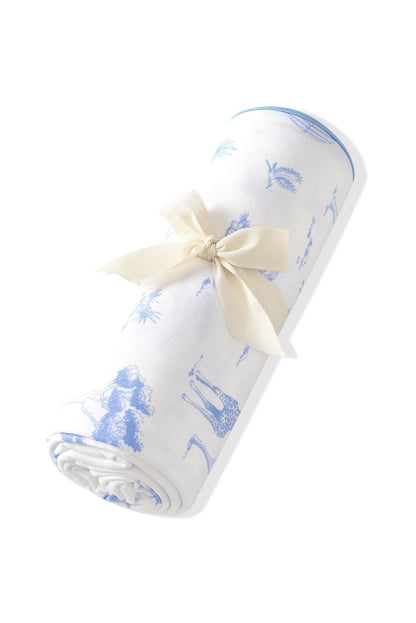 Swaddle Blanket in Toile Safari rolled in its packaging tied with a linen bow