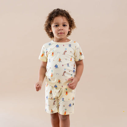 Young boy modeling the Toddler Basic Tee in Winnie the Pooh Celebration with matching drawstring shorts