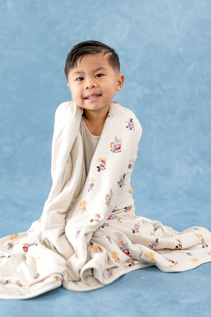 Child wrapped in a blanket with mickey and friends pattern