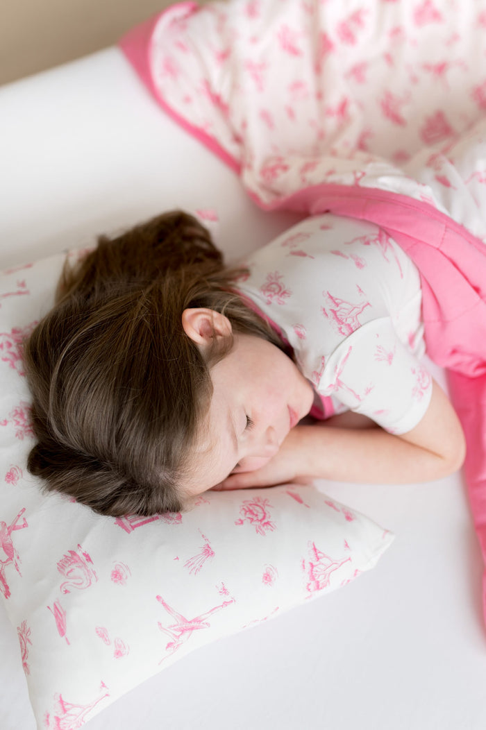 Young girl sleeping in a bed laying on a pillow with the Toddler Pillowcase in Toile Ballet on it