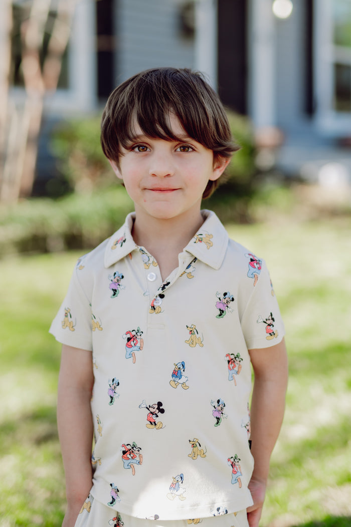 Young boy wearing a polo short sleeve shirt with mickey and friends pattern