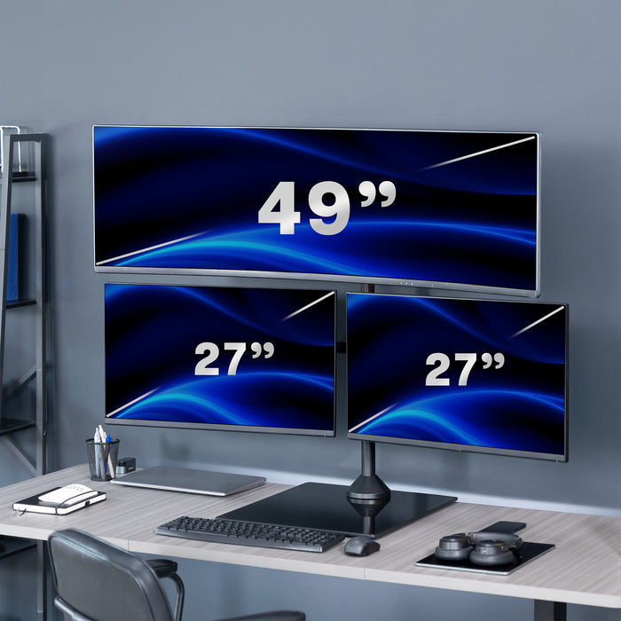 Three computer monitors displaying different sizes on a desk with office supplies.