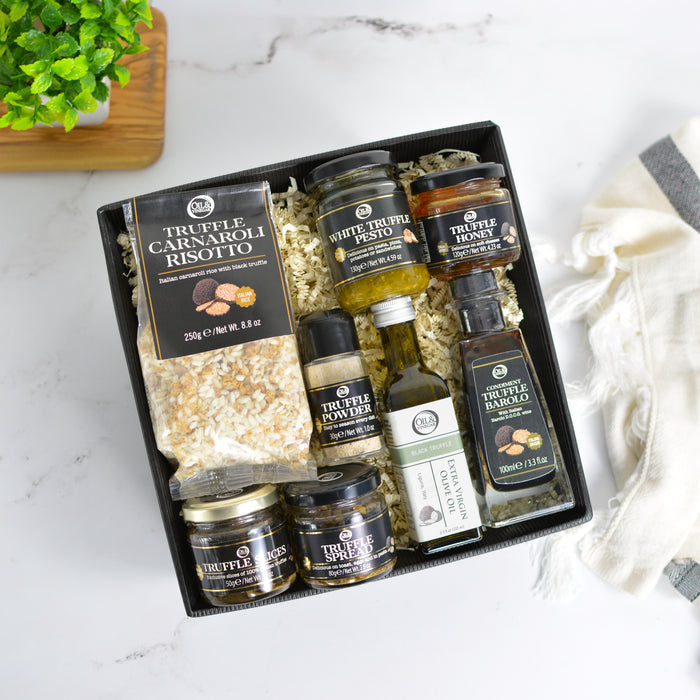 Collection of truffle products in a gift box on a marble surface.