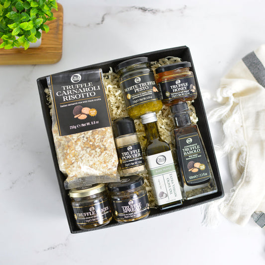 Collection of truffle products in a gift box on a marble surface.