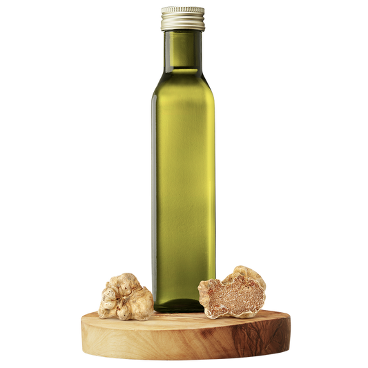 A bottle of extra virgin olive oil with a piece of white truffle next to it, all set on a wooden platform.
