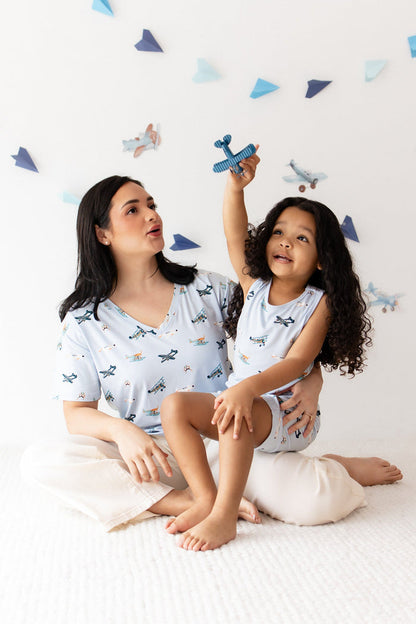 Mother sitting on the floor wearing the Women's Relaxed Fit V-Neck in Take Off with her daughter sitting on her lap matching in a toddler tank top and shorts