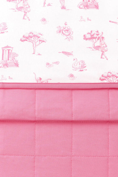 Close up of the Youth Blanket in Toile Ballet 1.0 showing the pink quilted backing and smooth printed top layer